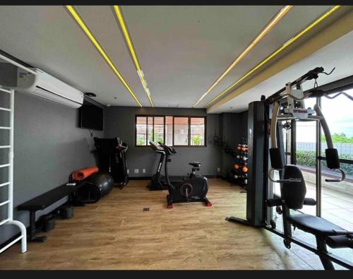 uma academia com esteiras e equipamentos de ginástica em uma sala em Flat Studio São Luís em São Luís