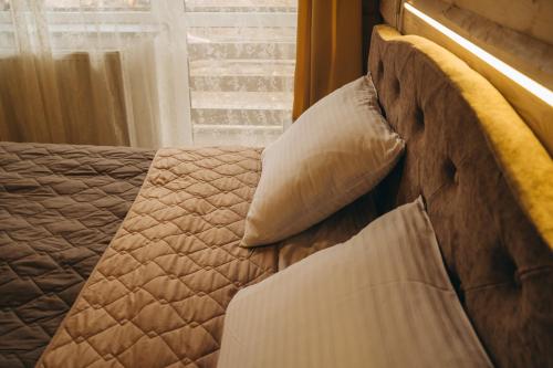 a bedroom with a bed with pillows and a window at SV HOTEL&camp in Lazeshchyna