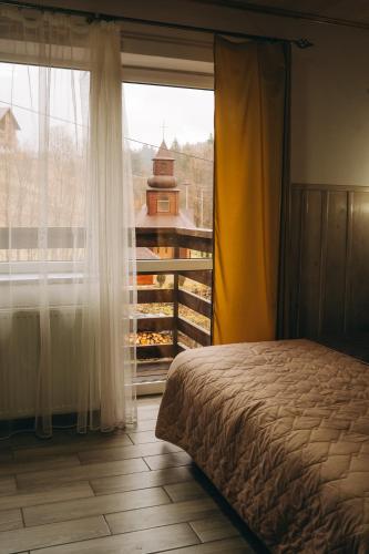 a bedroom with a bed and a large window at SV HOTEL&camp in Lazeshchyna