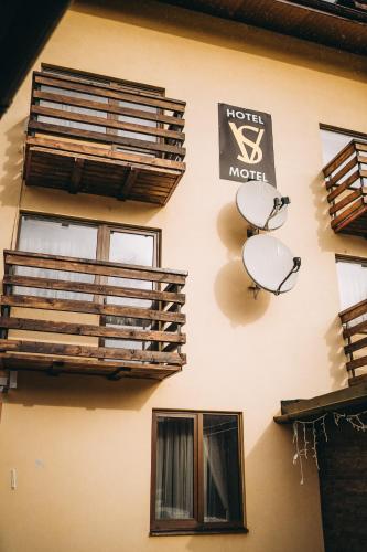 a wall with windows and a sign for a hotel motel at SV HOTEL&camp in Lazeshchyna