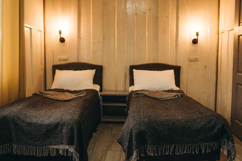 two beds sitting next to each other in a room at SV HOTEL&camp in Lazeshchyna