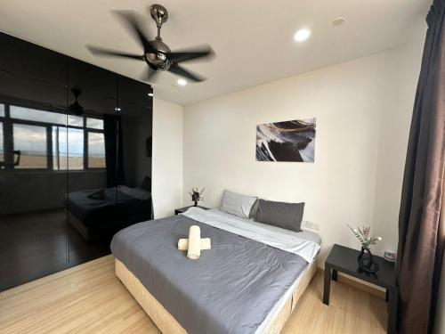 Un dormitorio con una cama con ventilador de techo. en Netflix Studio Seaview 118Island Plaza, en Tanjong Tokong