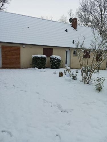 a house with snow on the ground in front of it at Gîte dans les bois en Normandie in La Houssaye