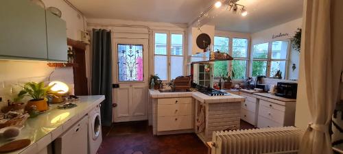 une grande cuisine avec un évier et une fenêtre dans l'établissement Originale maison individuelle au coeur de Paris !, à Paris