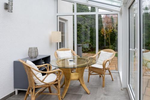 a dining room with a glass table and two chairs at Ganzes Ferienhaus in Leipzig mit Garage und Fußbodenheizung in Leipzig