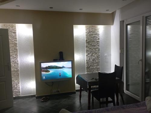 a living room with a television and a dining room table at Apartman BOKA in Banja Koviljača