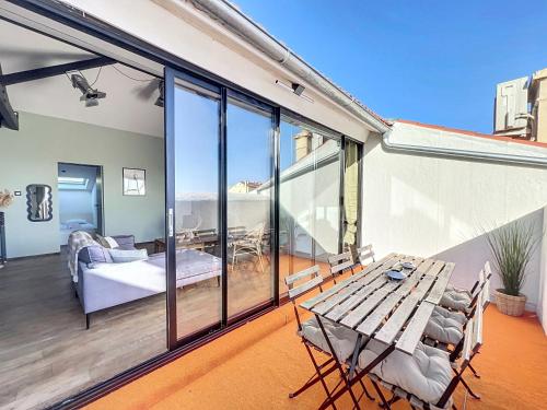 un patio avec une table et des chaises sur un balcon dans l'établissement 140m2 vue mer, 3 chambres, centre-ville, à Cannes