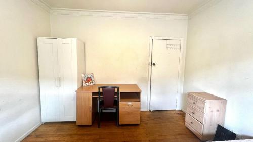 una stanza vuota con scrivania e sedia di Room near Tullamarine Airport a St Albans
