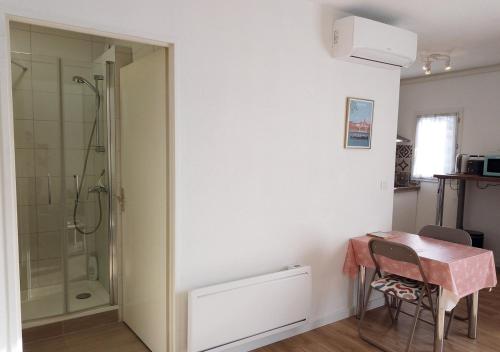 La salle de bains est pourvue d'une douche et d'une table avec une porte en verre. dans l'établissement Le BALCON de Balma - Calme, tout confort, clim, Wifi, parking, à Balma
