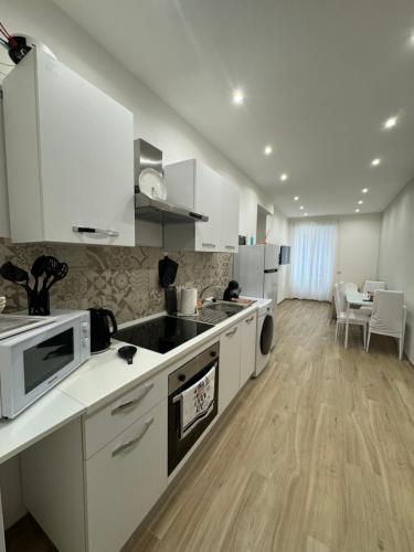 a kitchen with white appliances and a dining room at Dimora Appia in Rome
