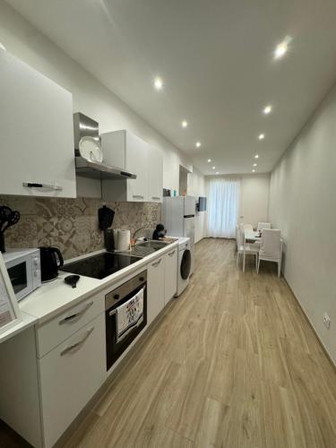 a large kitchen with white cabinets and a table at Dimora Appia in Rome