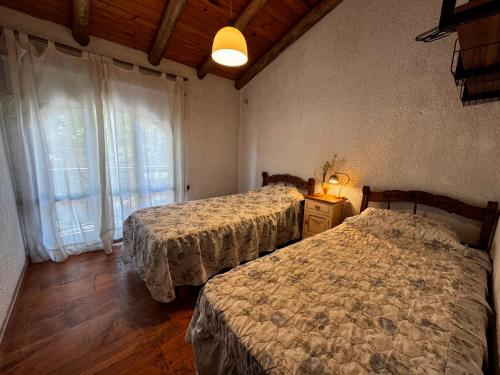 a bedroom with two beds and a window at Ruca Apartment in Tupungato
