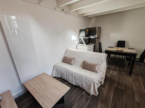 un salon avec un canapé et une table dans l'établissement Duplex atypique à La Rochelle avec parking privatif, à La Rochelle