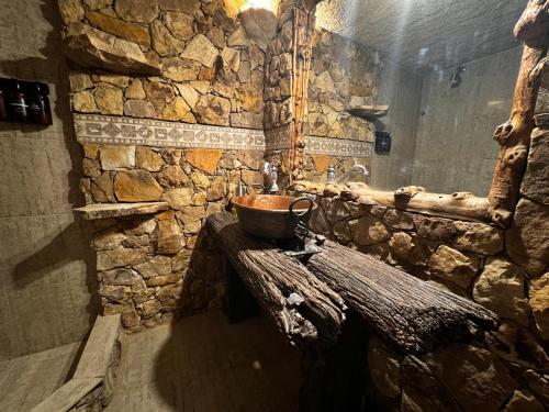 a stone bathroom with a bowl on a wooden table at Ruca Apartment in Tupungato