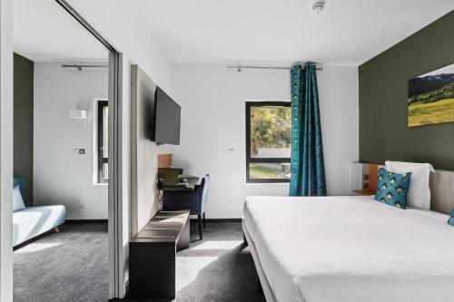 a hotel room with a bed and a mirror at Hôtel Restaurant AKENA Molinges - La Brocatelle in Saint-Claude