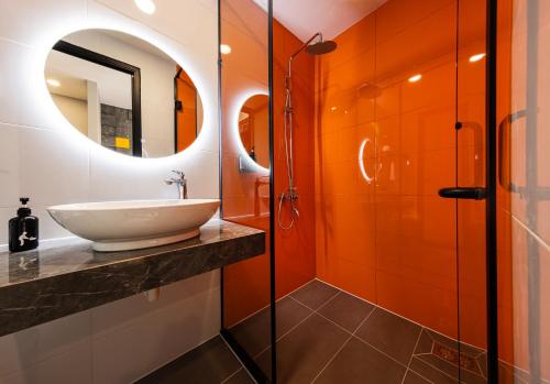 a bathroom with a sink and a mirror at The Hammock Hotel Global City in Ho Chi Minh City