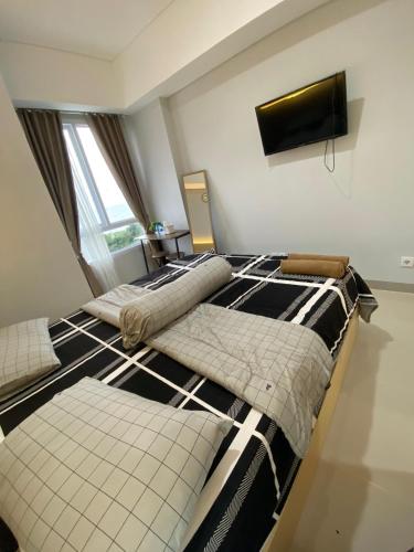 a bedroom with two beds and a flat screen tv at The Bay Apartment Lampung Ocean View in Kuala
