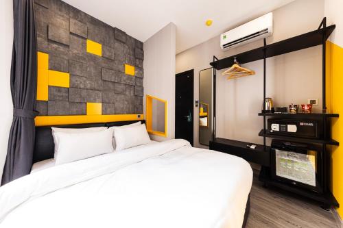 a bedroom with a bed and a wall with yellow squares at The Hammock Hotel Global City in Ho Chi Minh City