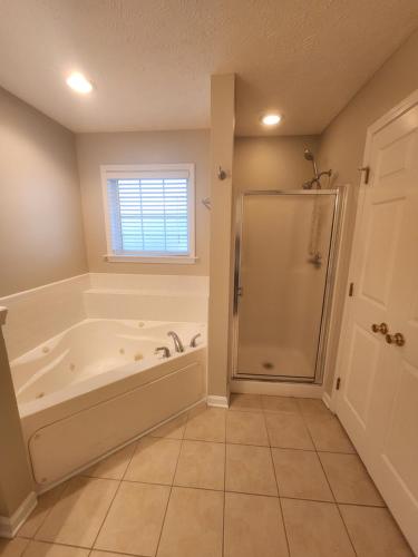 a bathroom with a shower and a bath tub at Haven Away From Home Ideal For Long Term Stays in Fayetteville