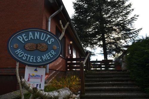 a sign for a restaurant with a sign for a cookie shop at Peanuts Hostel & Meer in Surendorf