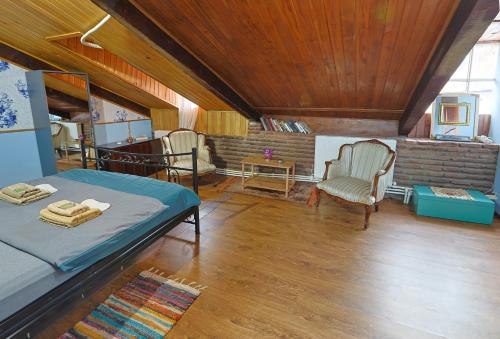 a bedroom with a bed and chairs in a room at Leon Rooms in Tbilisi City