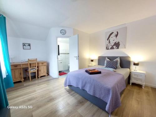 a bedroom with a bed and a desk and a bathroom at Hotel Radevormwald in Radevormwald