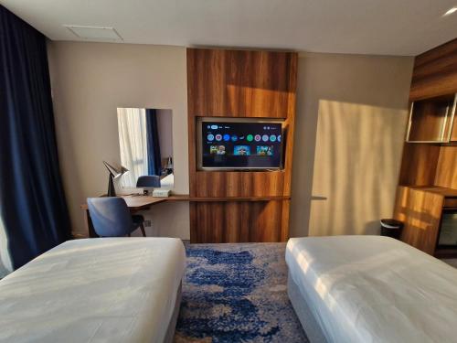 a hotel room with two beds and a flat screen tv at Ocean View Hotel Kuwait in Kuwait