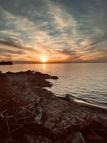 a sunset on the shore of a body of water at Genari Beach Apartments -Family sea view apartment in Korakokhórion