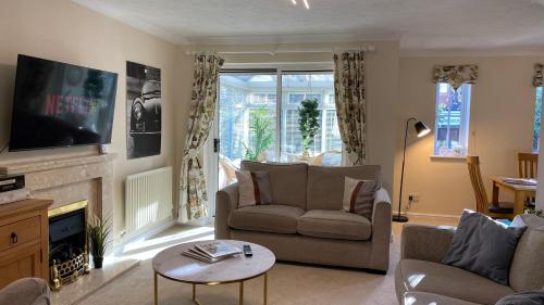a living room with a couch and a fireplace at Chichester retreat house with free parking in Chichester
