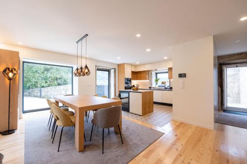 a kitchen and dining room with a table and chairs at Casa Da Romeira Country House in Freixieiro de Soutelo
