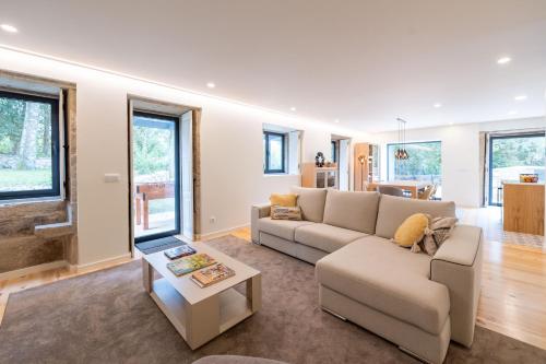 a living room with a couch and a table at Casa Da Romeira Country House in Freixieiro de Soutelo