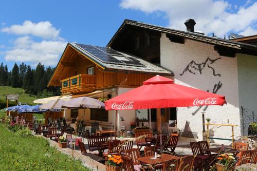 a restaurant with tables and umbrellas in front of a building at Landgasthof Schuster in Nesselwängle