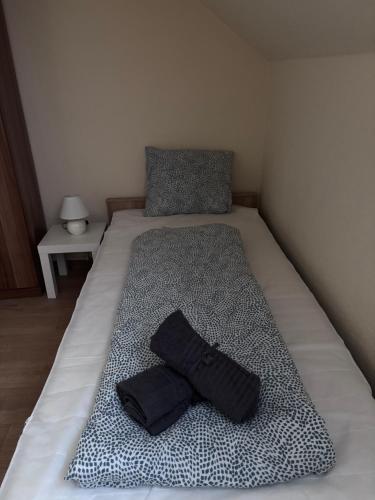 a bed with a black pillow on top of it at AIRPORTMAX Panzió in Vecsés