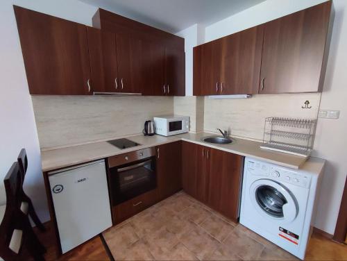 a kitchen with a washing machine and a microwave at "Mountain Dream" Apartments 200m from Ski Road in Bansko