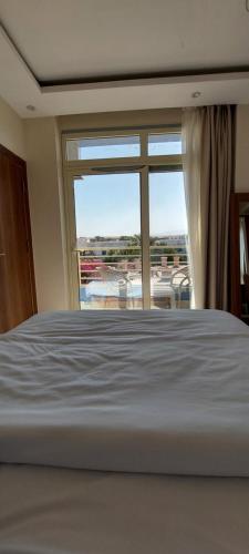 a bedroom with a bed and a large window at Hurghada Mirage Bay Hotel & Aquapark in Hurghada