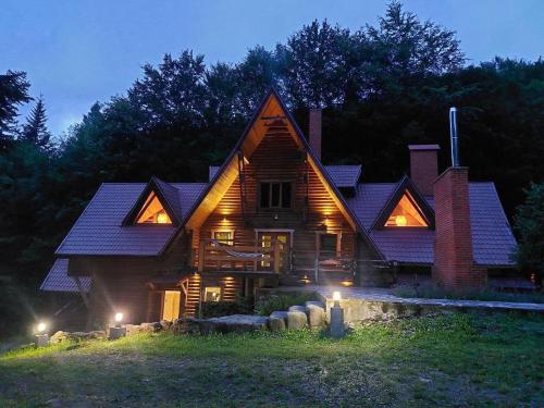 a large wooden house with lights in front of it at Voronins Retreat House in Lumshory