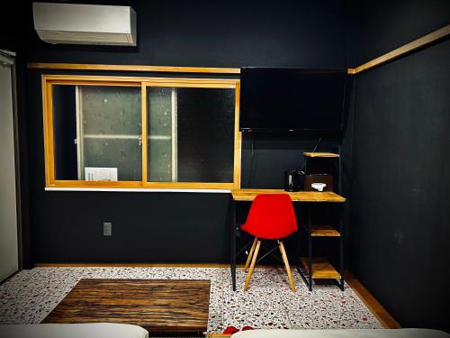 a room with a red chair and a desk with a window at 祇園鞆家 貸切の御宿 大人数宿泊オススメ& 連泊weeklyぶちお得 in Tomo