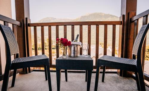 a table with a vase of flowers on a balcony at Hôtel Le Montaigu in Luz-Saint-Sauveur
