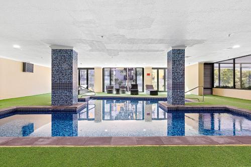 a swimming pool with two columns in a building at 14 Roomy Restrelax Eastperth 2brparking in Perth