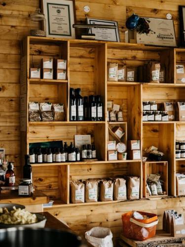 a store with wooden shelves filled with bottles and food at Móðir Jörð Organic Farm Guesthouse in Vallanes in Vallanes