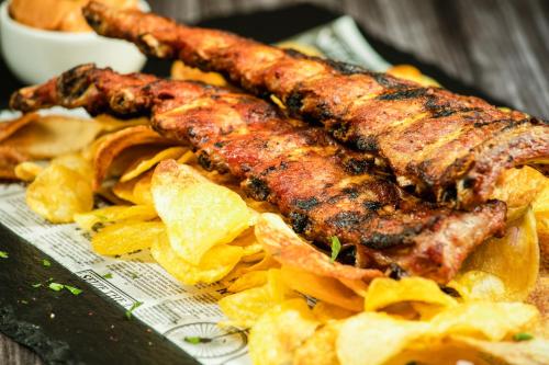 a plate of food with meat and potato chips at Q Resort and Spa in Săcele