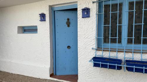 a blue door on a white building with a window at Torre Calera in Arganda del Rey