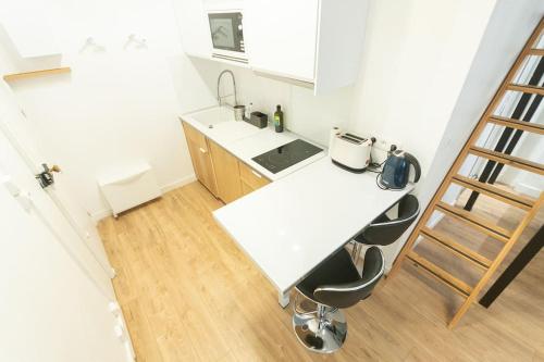 une cuisine avec un comptoir blanc et une échelle dans l'établissement La Mezzanina - Hypercentre - Gare, à Angers