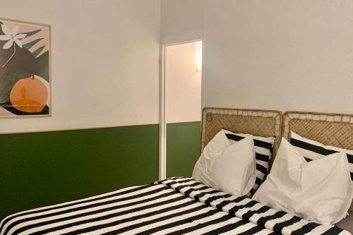 - un lit avec des oreillers en noir et blanc dans l'établissement Studio Lumineux 2 Pers Centre, à Toulouse