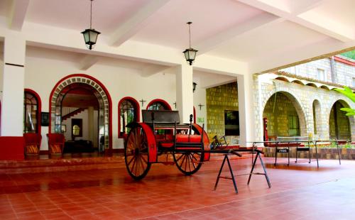 a red carriage on display in a building at Hotel SPA Taninul in Los Puentes