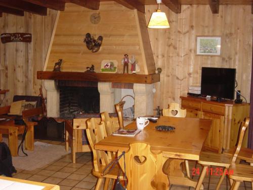 a dining room with a table and a fireplace at L'arpont in Champagny-en-Vanoise