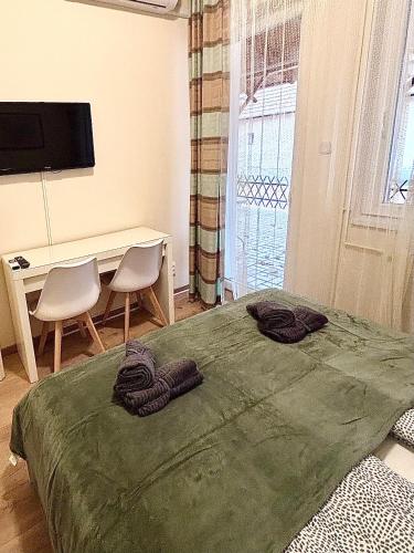 a bedroom with a bed and a desk and a television at AIRPORTMAX Panzió in Vecsés