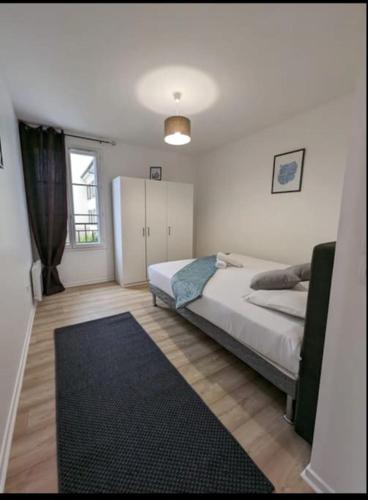 - une chambre avec un lit et un tapis noir dans l'établissement Chic appartement à 5 minutes de bus de Disneyland, à Serris