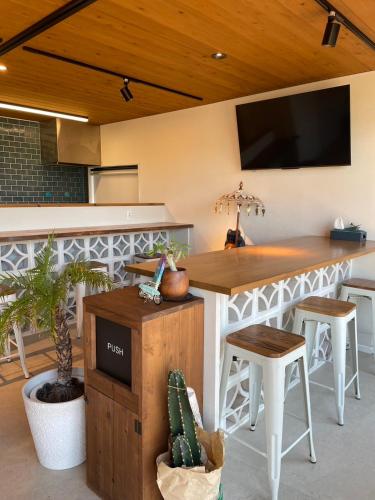 a kitchen with a bar with a tv on the wall at Glam Pool Terrace Shizunami in Makinohara