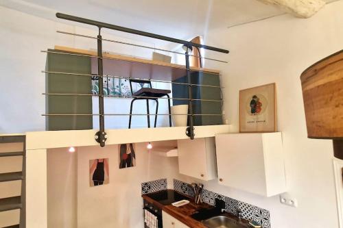 une cuisine avec des armoires blanches et un évier dans l'établissement Cocon ensoleillé centre ville historique, Clim Wifi 4 people, à Aix-en-Provence